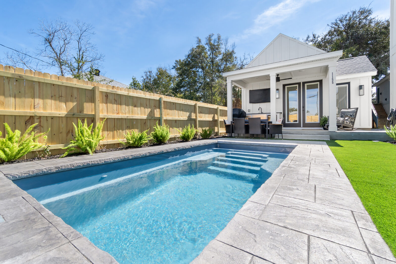 Pool loungers and turf backyard at an AJAC Group ADU project