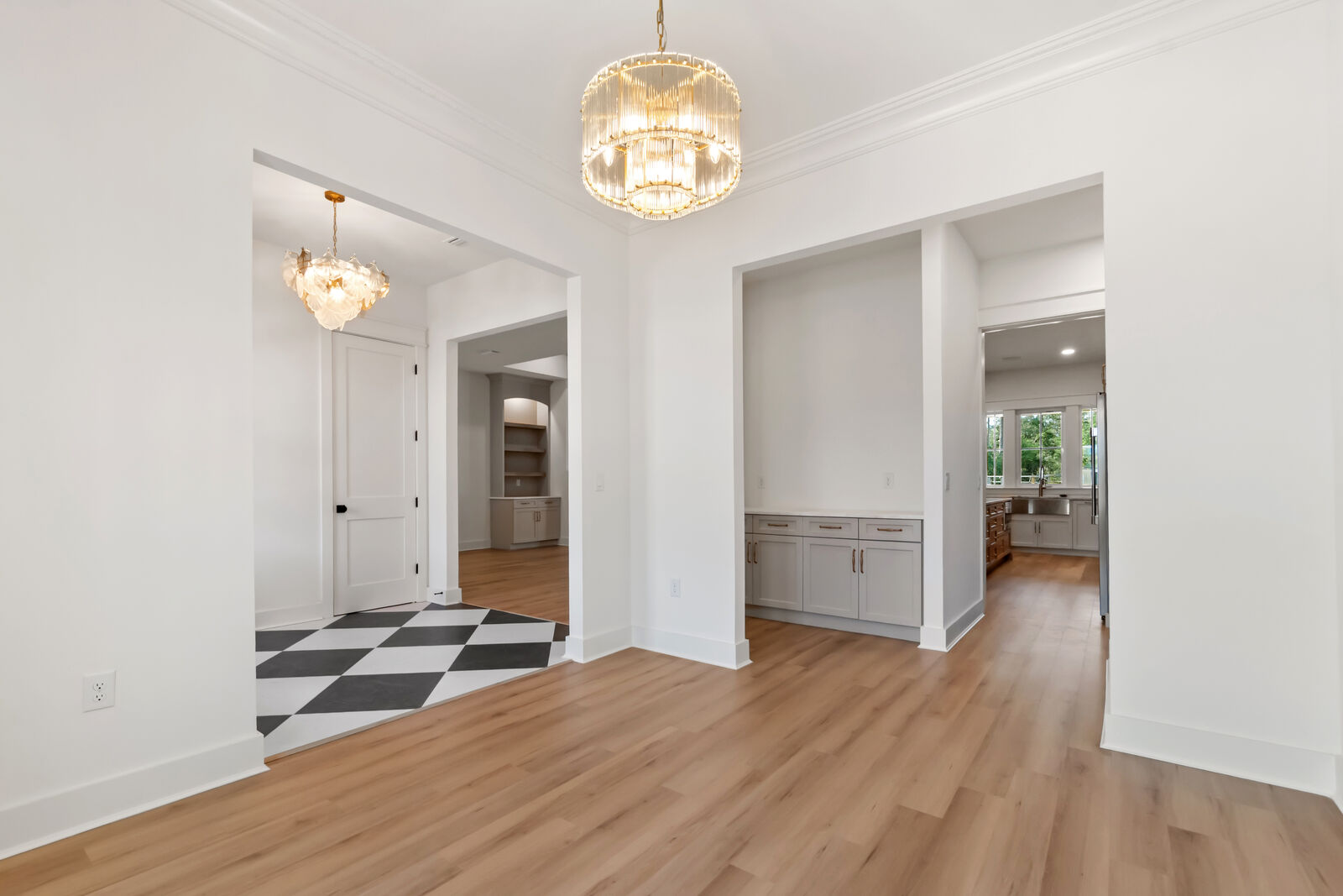 Entry hall with chandeliers and checkerboard accents in an AJAC Group custom home