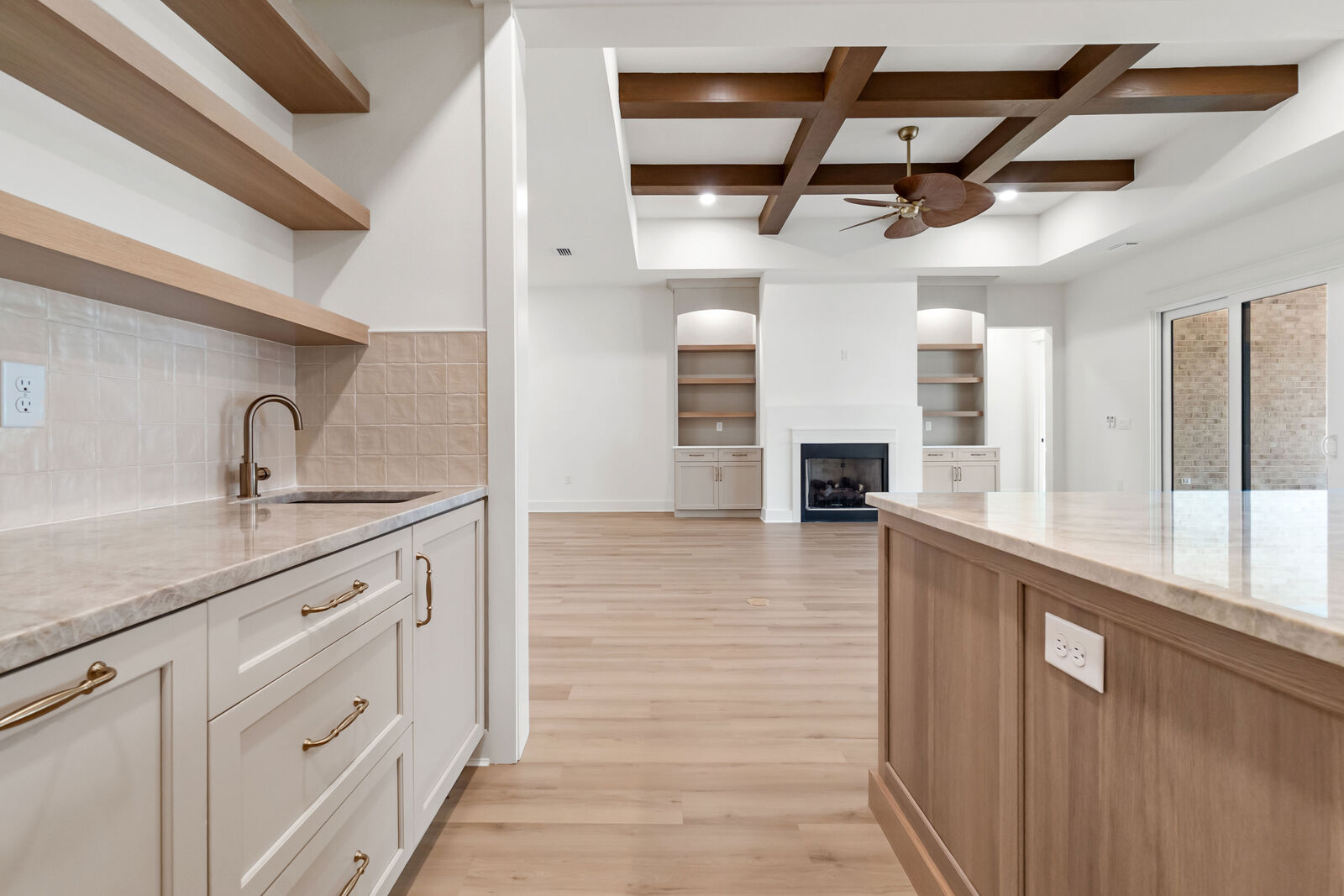 Kitchen sink view into the coffered great room of an AJAC Group custom home