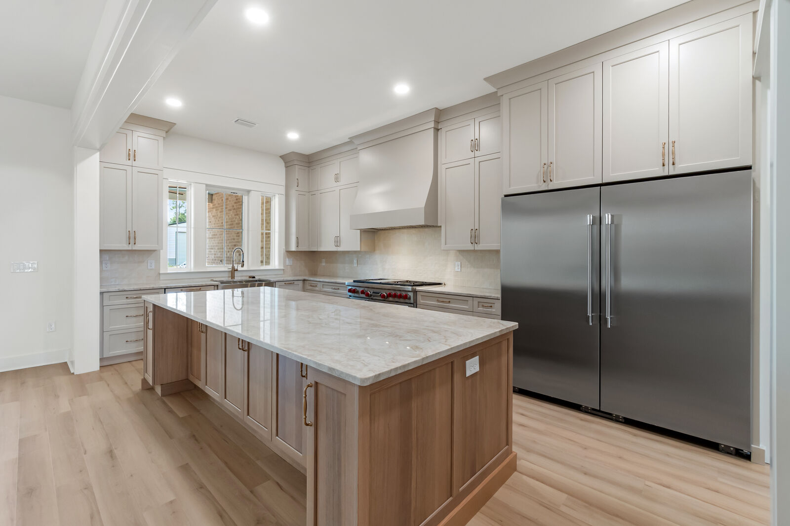 Kitchen island and paneled refrigerator in an AJAC Group custom home