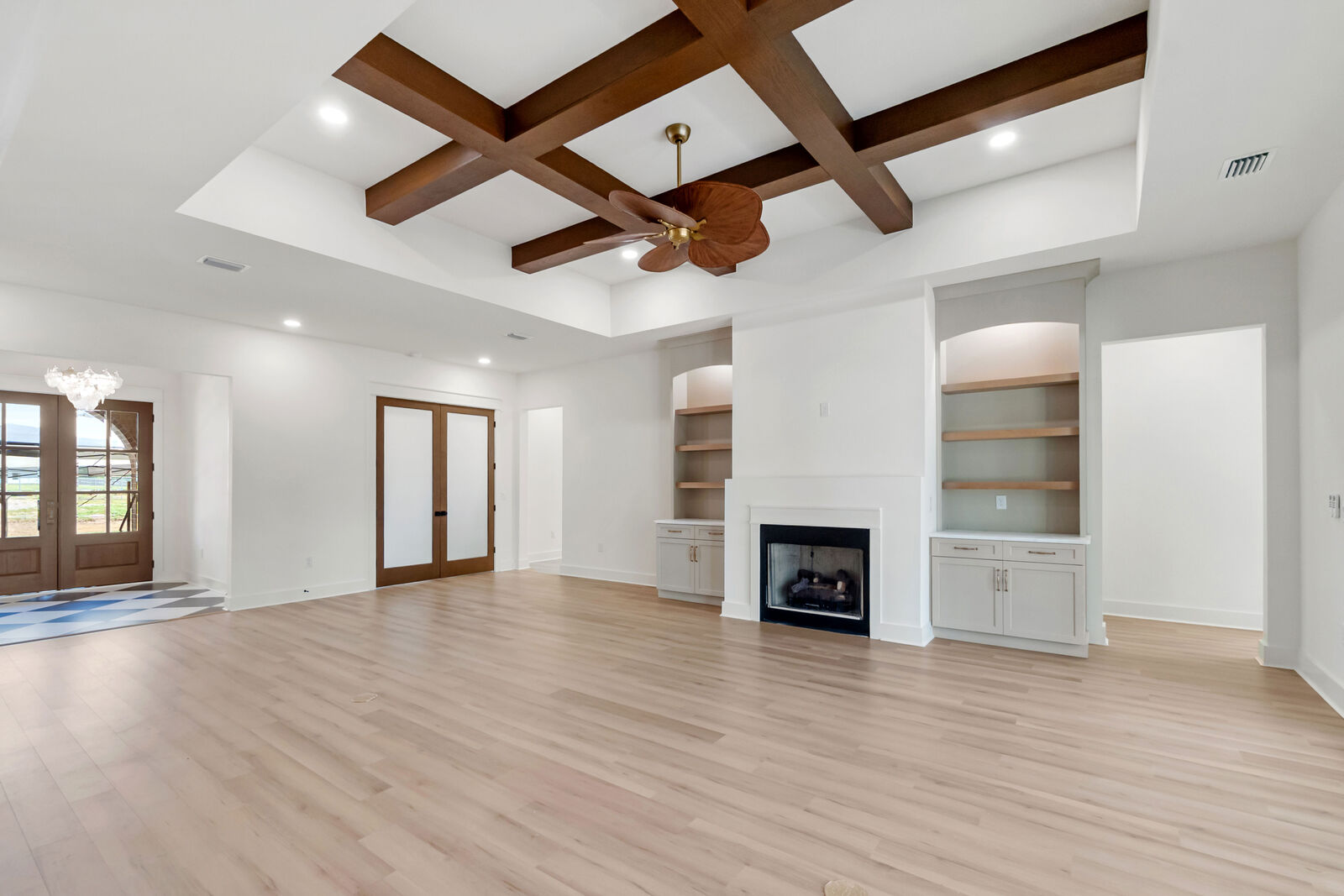 Living area with wood beams, fireplace, and built-ins in an AJAC Group custom home