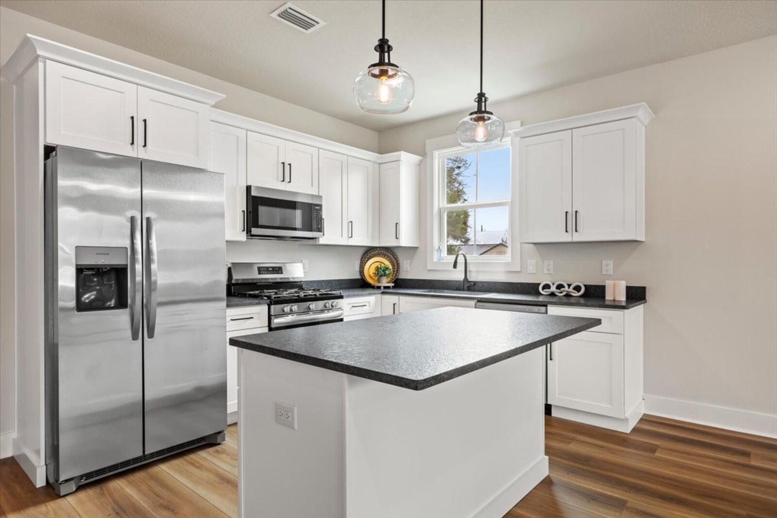 Open kitchen with island and pendant lighting in an AJAC Group new construction home